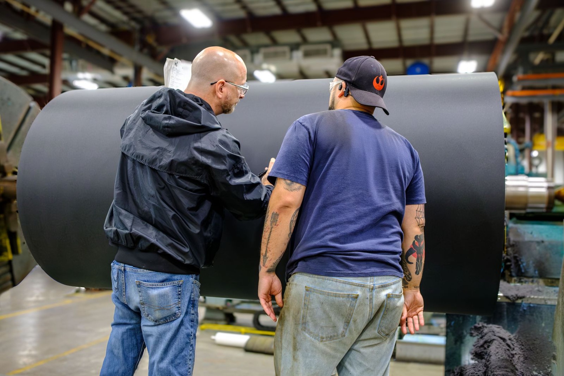 Workers inspecting a large roll